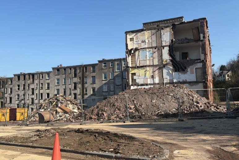 A part-demolished block of flats beside a cleared site